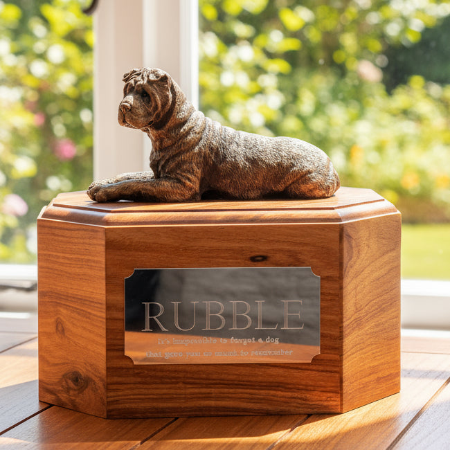 Wooden urn with a bronze dog figurine on top, placed indoors.
